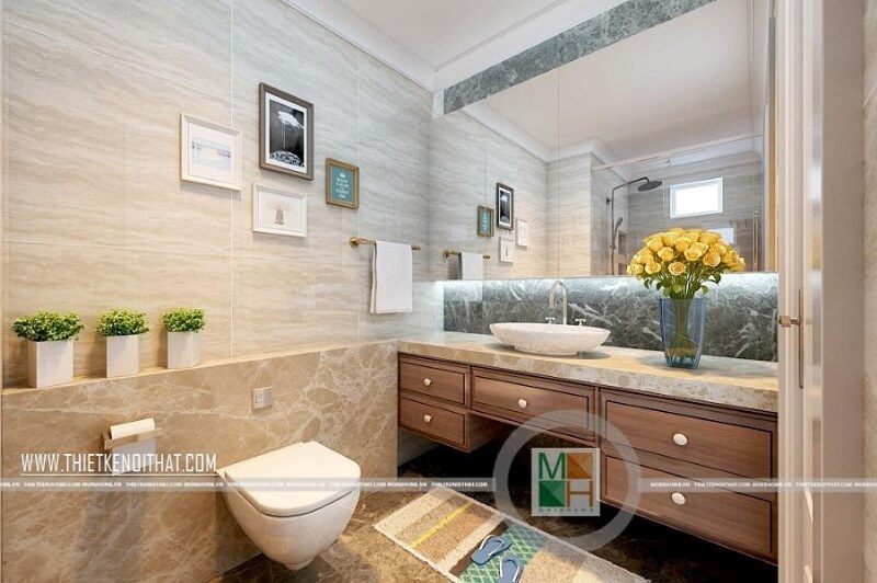 Thiết kế phòng tắm chung cư hiện đại với trang thiết bị vệ sinh cao cấp kết hợp kệ tủ gỗ màu óc chó mang đến sự sang trọng và tinh tế.